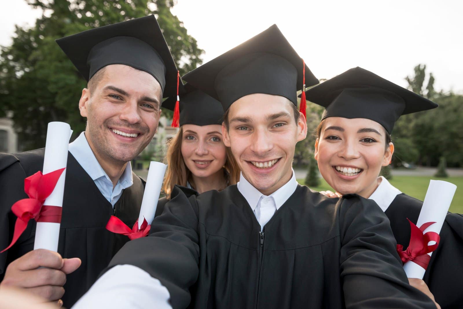 Group of graduates celebrating by tossing caps into the air during a graduation ceremony.